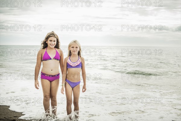 Girls smiling in waves on beach