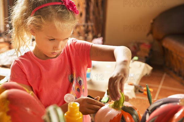 Caucasian girl decorating jack o'lantern