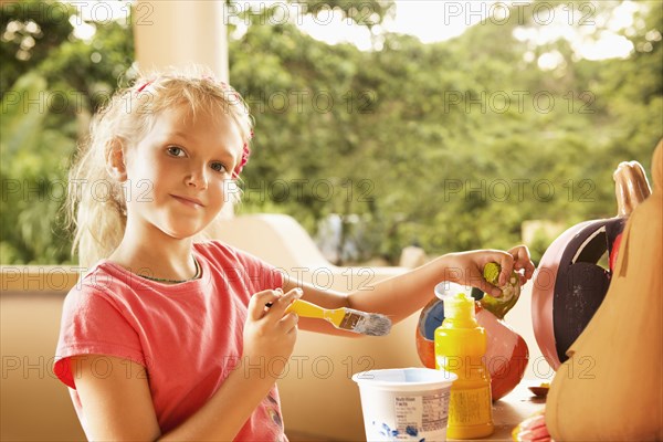 Caucasian girl decorating jack o'lantern