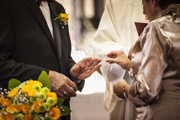Senior couple exchanging rings at wedding