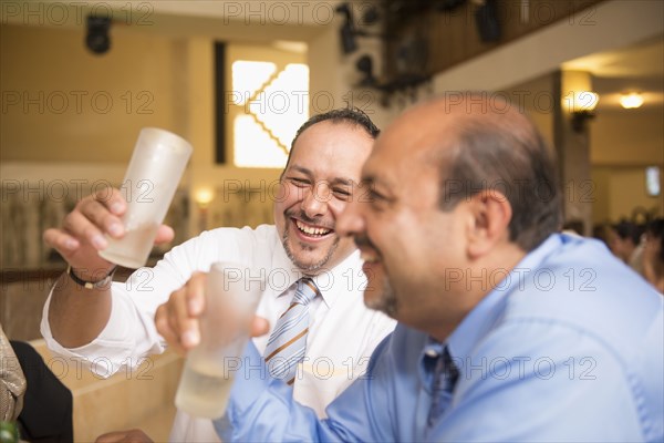 Hispanic men drinking at wedding reception