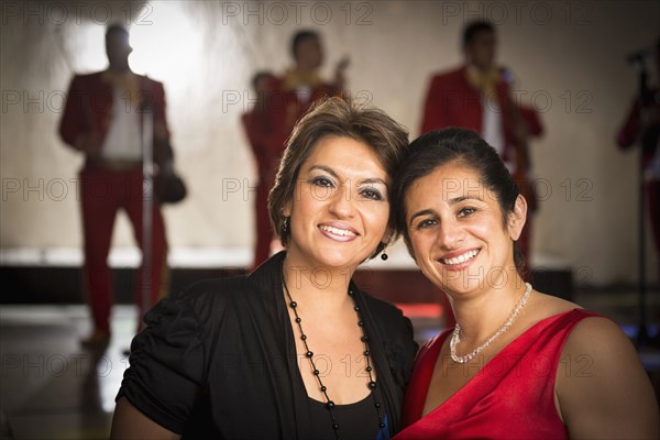 Hispanic women smiling at wedding reception