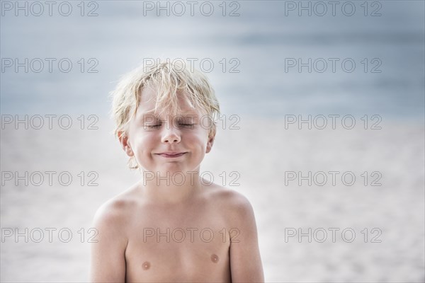 Caucasian boy smiling on beach