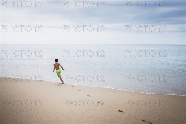 Mixed race boy playing on beach