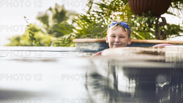 Caucasian boy smiling in swimming pool