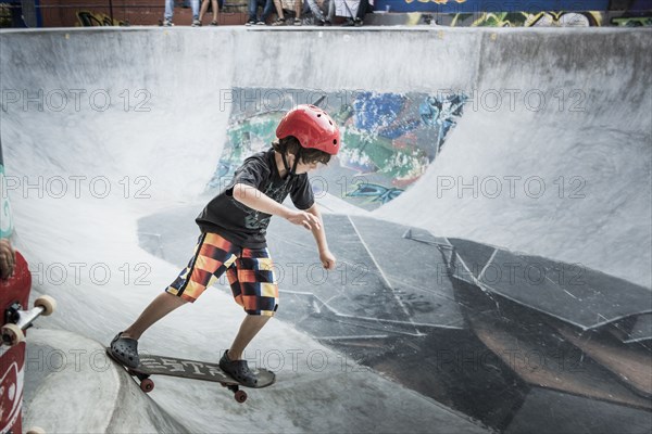 Caucasian boy riding skateboard in skate park