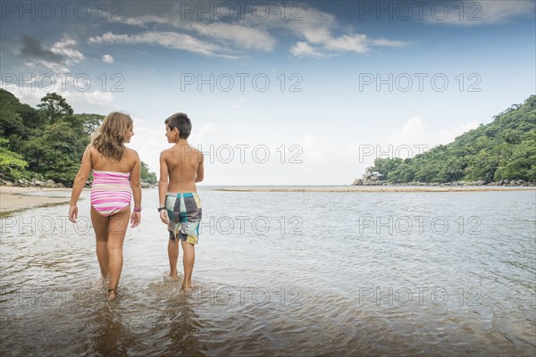 Children walking together in water