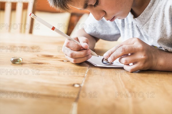 Mixed race boy coloring at desk