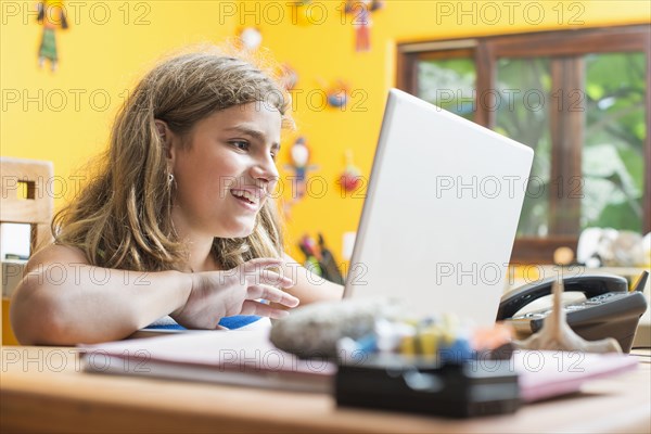 Mixed race girl using laptop at desk