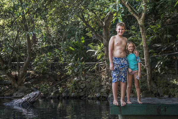 Caucasian children smiling by rural lake