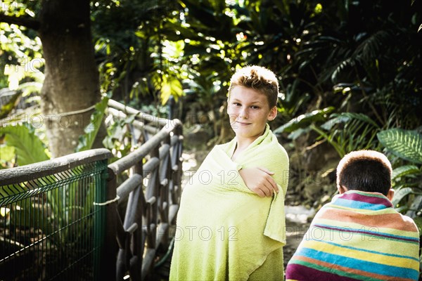 Boys wrapped in towels in jungle