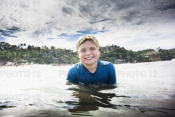 Caucasian boy swimming in ocean