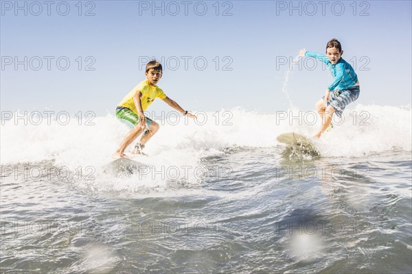 Boys surfing in ocean