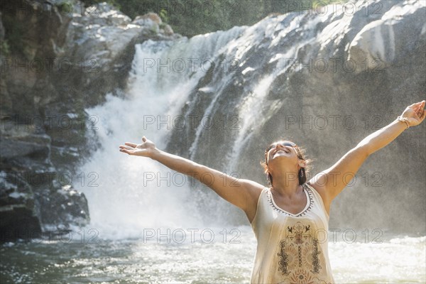 Hispanic woman standing by waterfall