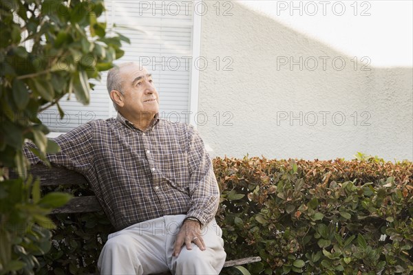 Hispanic man sitting outdoors