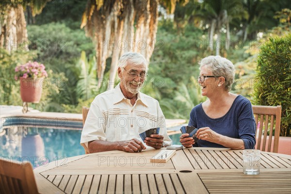 Caucasian couple playing cards outdoors