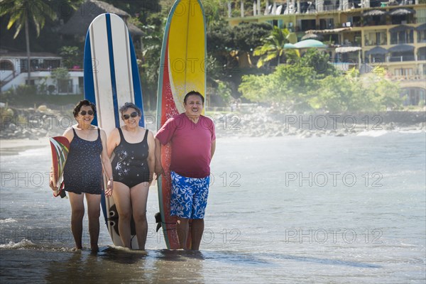 Hispanic friends with surfboards on beach