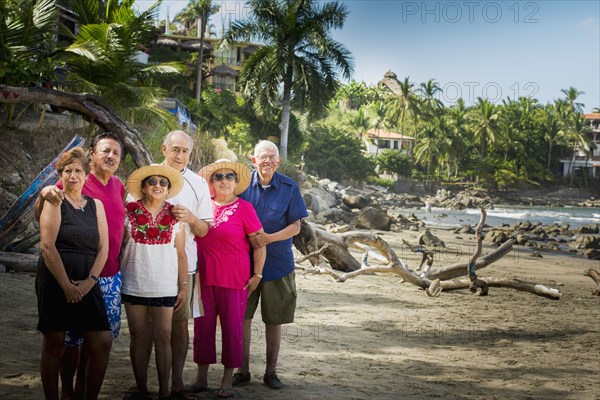 Hispanic friends smiling together on beach