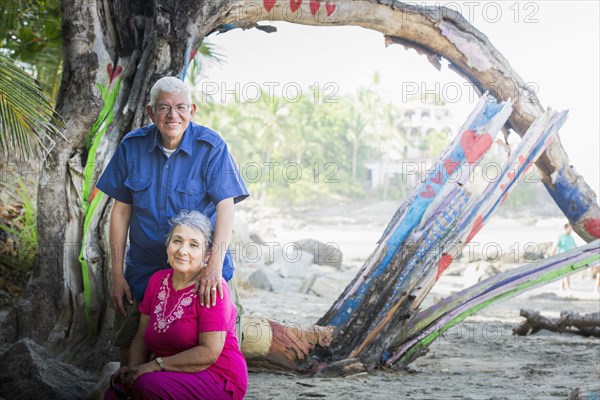 Hispanic couple smiling on beach