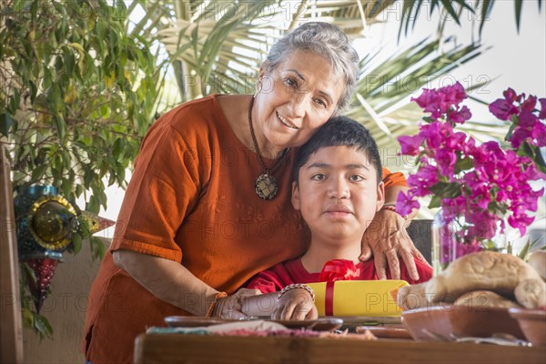 Older Hispanic woman hugging grandson