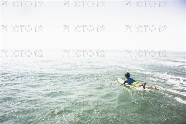 Caucasian boy surfing in ocean