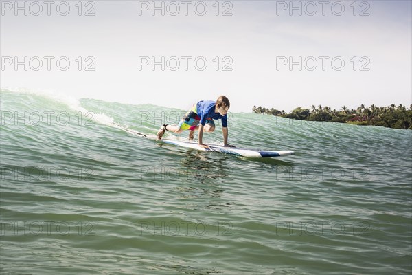 Caucasian boy surfing in ocean