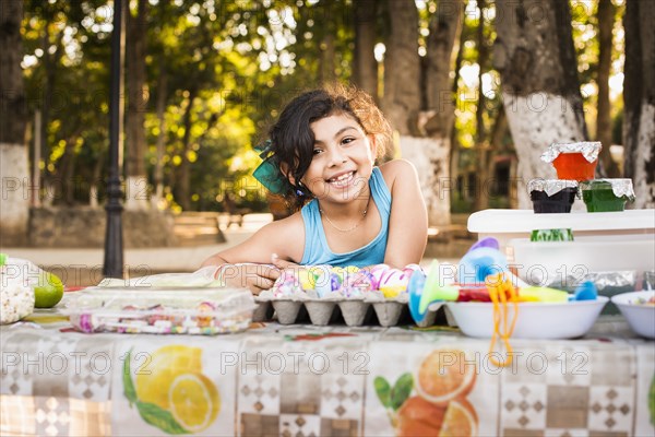 Hispanic girl smiling with Easter eggs