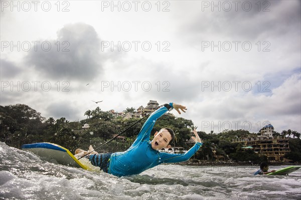 Boys surfing together in waves