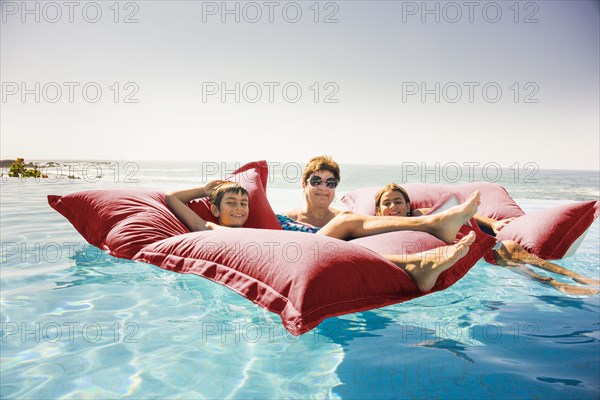 Grandmother and grandchildren relaxing on pool raft