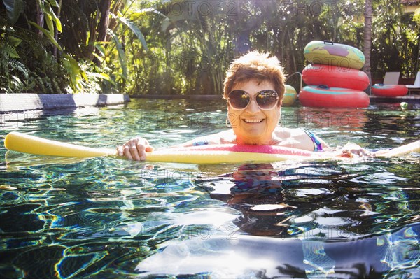 Older woman with sunglasses in swimming pool