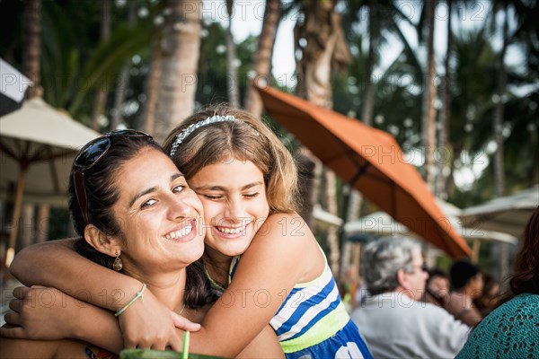 Mother and daughter hugging outdoors