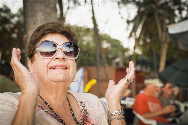 Older woman clapping outdoors