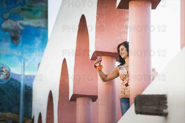 Low angle view of Hispanic woman taking photograph