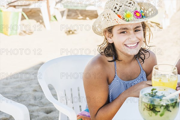 Mixed race girl wearing cowboy hat at table