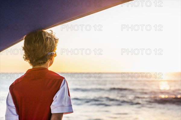 Caucasian boy admiring ocean sunset