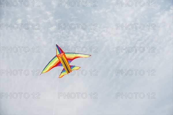 Colorful airplane kite flying in blue sky