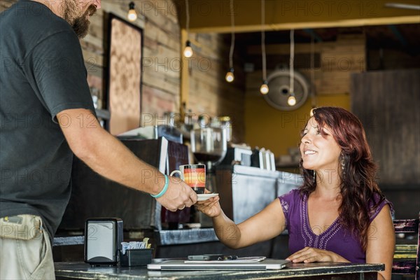 Hispanic woman having coffee in cafe