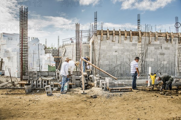 Construction workers building cinder block wall