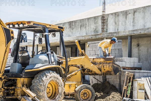 Hispanic construction worker on bulldozer at construction site