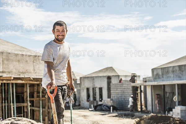 Hispanic construction worker with shovel at construction site