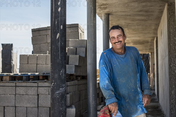 Hispanic construction worker smiling at construction site