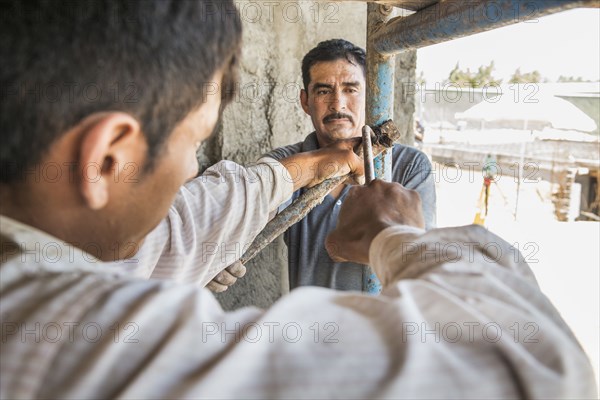 Hispanic construction workers with scaffolding at construction site