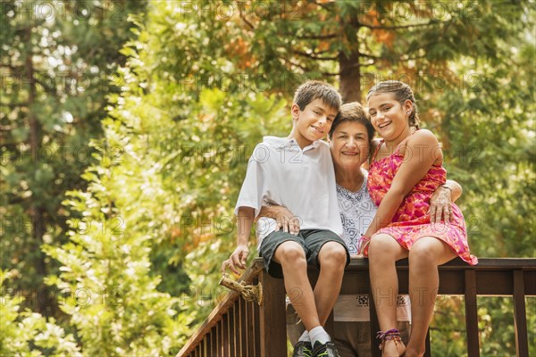 Grandmother and grandchildren smiling on banister