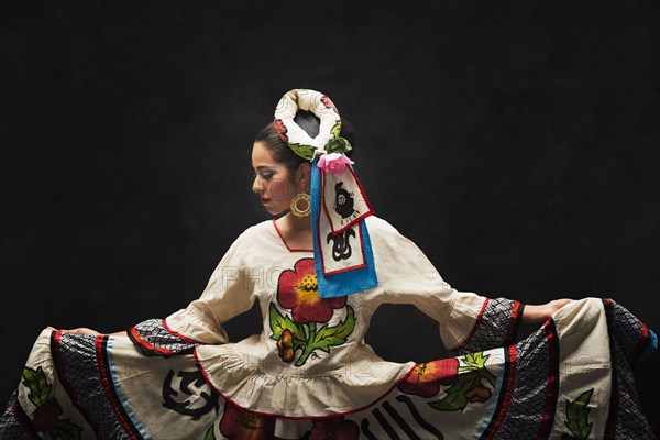 Hispanic teenage girl dancing in Sinaloa Folkloric dress