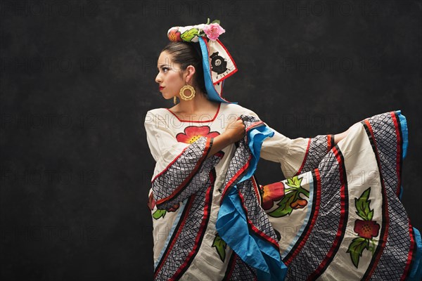 Hispanic teenage girl dancing in Sinaloa Folkloric dress