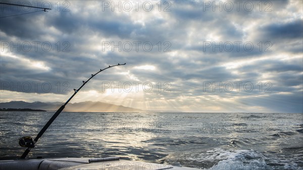 Fishing poles on boat over ocean waves