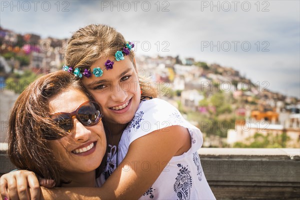 Close up of mother and daughter hugging on rooftop