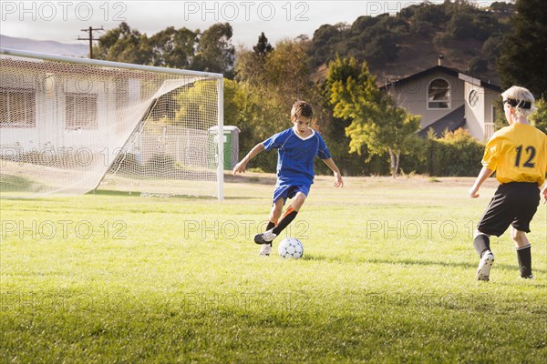 Boys playing soccer on field