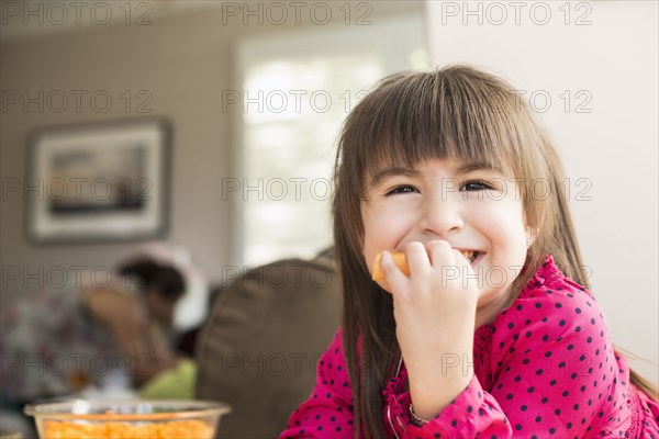 Smiling Hispanic girl eating fruit