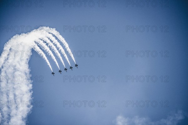 Jets flying in formation in cloudy blue sky